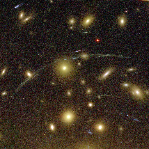 An image of the galaxy cluster Abell 1689 actings as a gravitational lens, with arcs of background galaxies around it.
