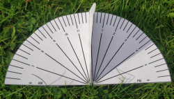 A paper sundial lying on the grass