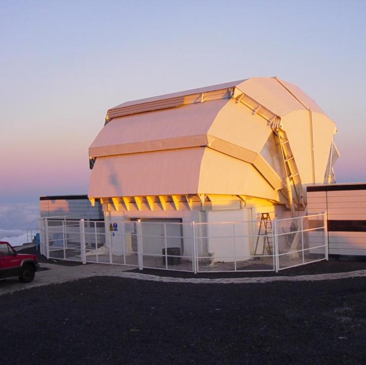 A photo of the Liverpool telescope clamshell enclosure closed with the dawn light falling upon it.