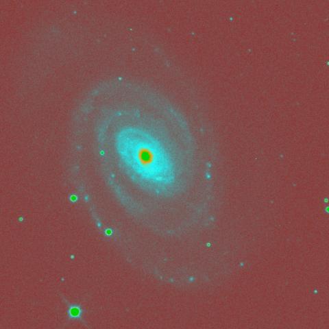 A false-colour cyan and dark red image of a spiral galaxy