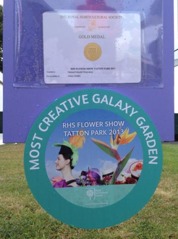 A display sign showing awards from the RHS Flower Show Tatton Park 2013, including a Gold Medal and a “Most Creative Galaxy Garden” prize presented to the National Schools’ Observatory.
