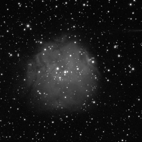 A spherical nebula against a black background with some small white dots of stars. The nebula is cloud-like, grey, and fuzzy.