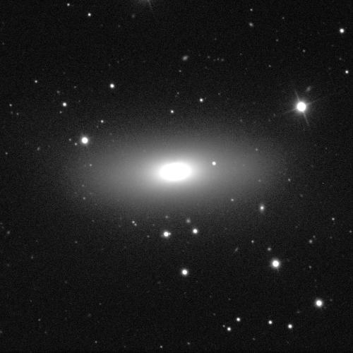 A black background with white dots of stars. A large, bright oval is in the centre, stretched slightly horizontally. It is surrounded by a fuzzy, cloud-like, light grey disc also stretching horizontally.