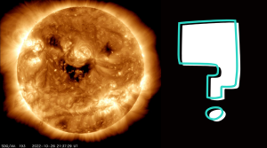 An image of the Sun closer up. There are 3 large dark patches on it that look like a smiling face. There is a large question mark to the right of the Sun.